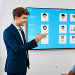 **Prompt for an innovative, technology-driven therapy session:**
    A professional speech therapist, fully clothed in a modest business suit, gently guides a young adult client, fully clothed in appropriate casual wear, in a modern, well-lit speech therapy clinic. The client is engaged with a futuristic AI-powered interactive screen displaying real-time speech analysis data and personalized exercises. In the background, a subtle holographic projection shows a simulated social environment, hinting at Virtual Reality (VR) practice. The therapist offers encouraging guidance, showcasing a holistic and technology-integrated approach to communication training. The setting is clean and professional, with an emphasis on advanced tools aiding human connection. Professional photography, sharp focus, vibrant colors, perfect anatomy, correct proportions, natural pose, well-formed hands, proper finger count, natural body proportions, safe for work, appropriate content, fully clothed, family-friendly.